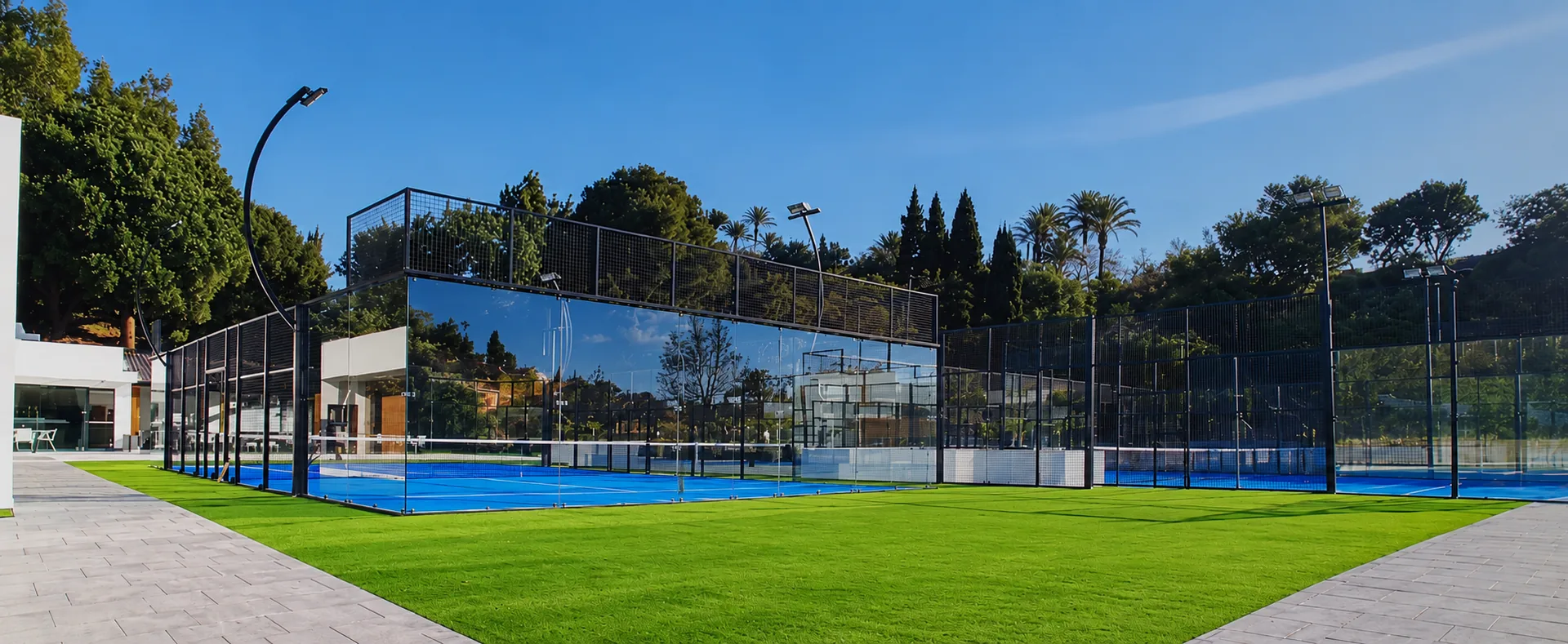 Glass padel courts with a blue surface on the Costa del Sol