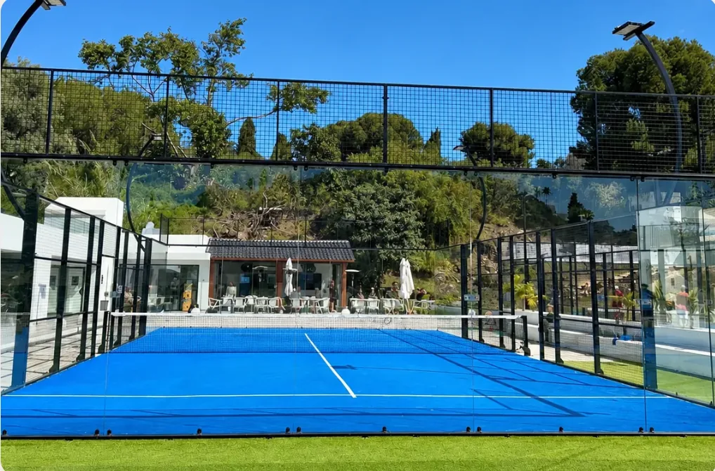 Blue padel court with glass walls in Málaga